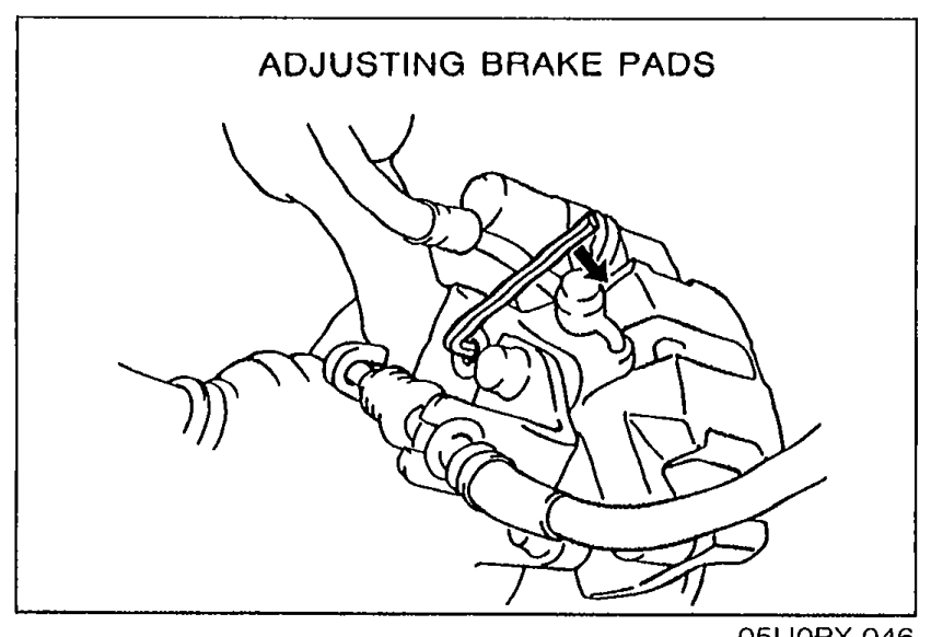 Illustration titled ADJUSTING BRAKE PADS showing an Allen wrench inserted into the rear caliper's manual adjustment gear to turn it clockwise until the pads contact the disc plate.