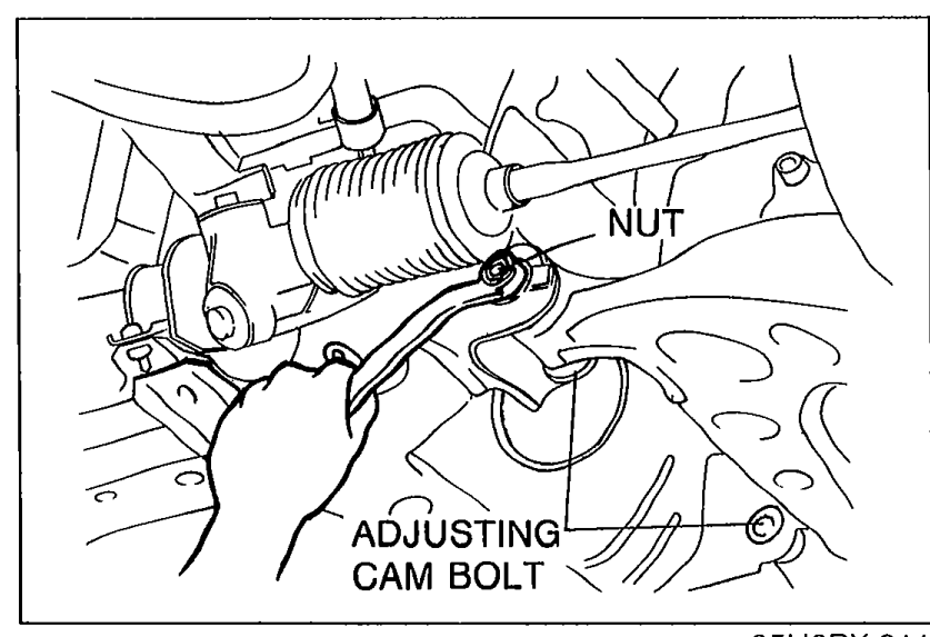 Photo showing a hand wrenching the adjusting cam bolt and cam nut at the lower arm for caster adjustment. Callouts label NUT and ADJUSTING CAM BOLT.