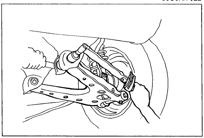 Photo of the rear suspension lower arm assembly with the adjusting cams visible at the inboard mounting points.