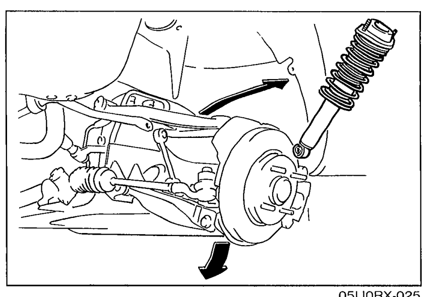 Front suspension removal-note illustration showing the lower arm being lowered with an arrow indicating the downward motion to release the shock absorber. Strut/shock visible above the wheel hub area.