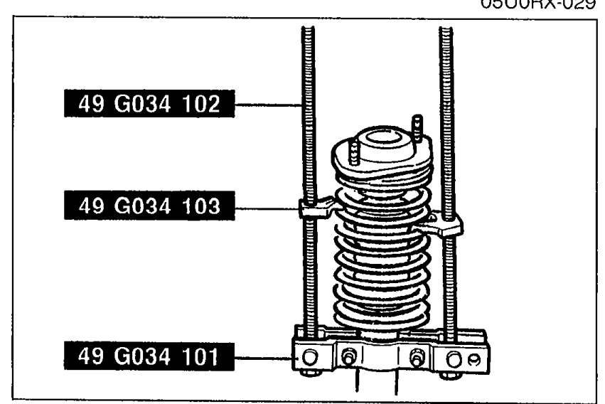 Compressed coil spring being installed onto the shock absorber using SST 49 G034 1A0 components (49 G034 102 screw, 49 G034 103 arm, 49 G034 101 body).