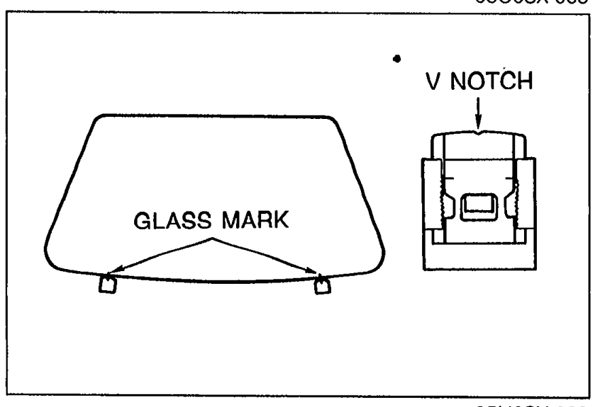 Bottom view of the windshield showing the GLASS MARK at the bottom edge aligning with a V NOTCH cut into the body-side SPACER. Illustrates the glass-to-spacer alignment in step 8.