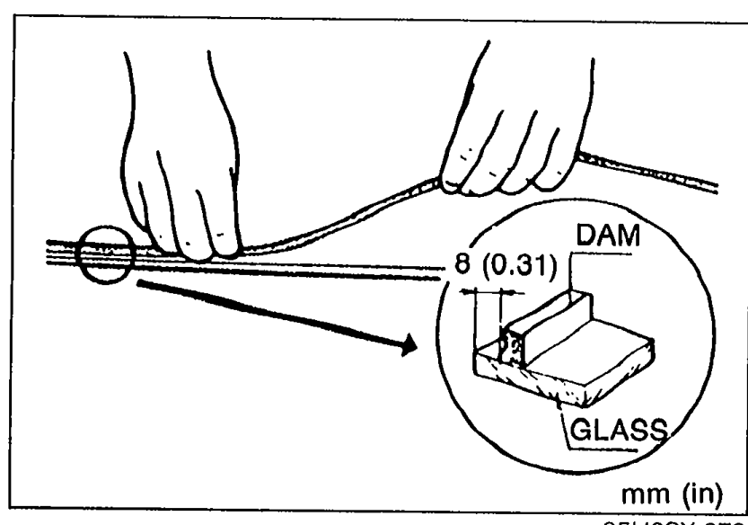 Hands bonding a new DAM along the circumference of the rear window GLASS at 8 mm (0.31 in) from the edge. Inset detail at right shows DAM bonded to GLASS with the 8 (0.31) mm dimension.