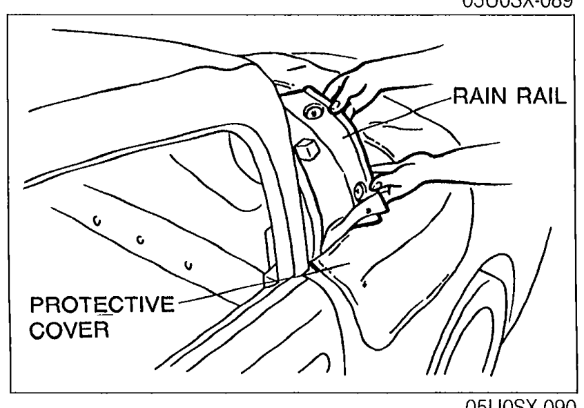 Rain rail being lifted away from the body with a protective cover placed underneath to prevent damage to the body paint.