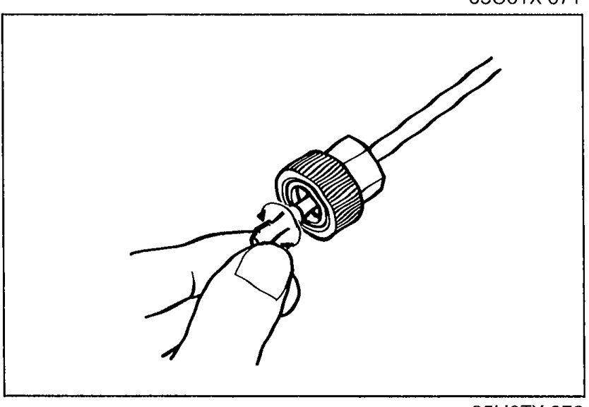 Speedometer cable end being held by hand showing the cable and gear for spin/rotation check.