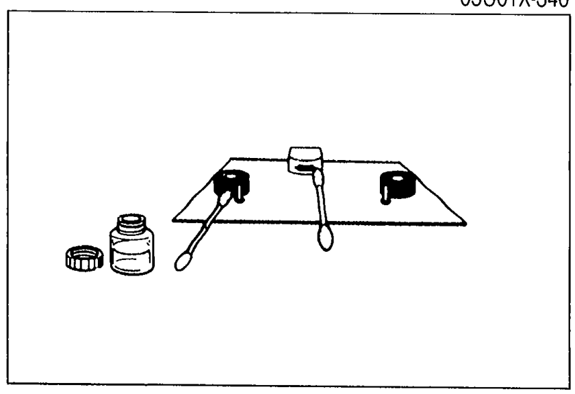 Head cleaning supplies on a cloth — bottle of head cleaner, swab, and a cassette head cleaning tool laid out.