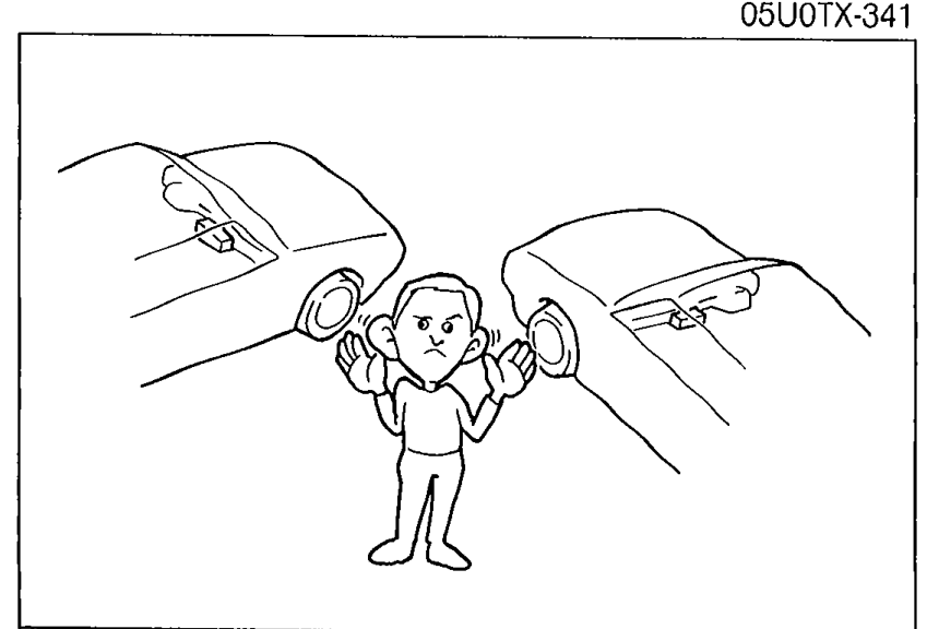 Person inside a car listening with hands cupped to ears, indicating sound quality comparison.