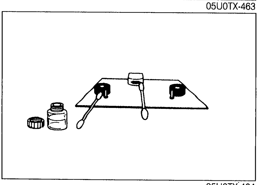 Head cleaning supplies on a cloth — bottle of head cleaner, swab, and a cassette head cleaning tool laid out.