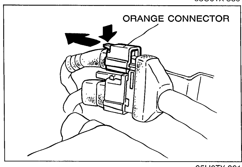 Orange connector being disconnected by pressing orange knob.