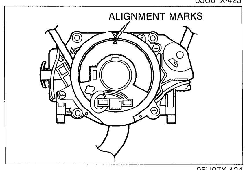 Close-up of the clock spring connector with the label 'ALIGNMENT MARKS' pointing to alignment marks on the connector and outer housing.