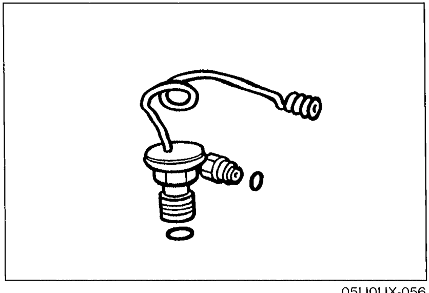 Close-up of the expansion valve assembly with the inlet/outlet pipes and capillary tube attached, illustrating the part being replaced in the procedure.